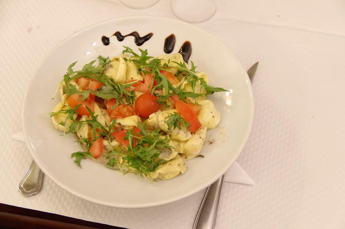 Tortellini Venezia : pâtes fraîches farcies, crème de truffe, tomates fraîches et roquette.
