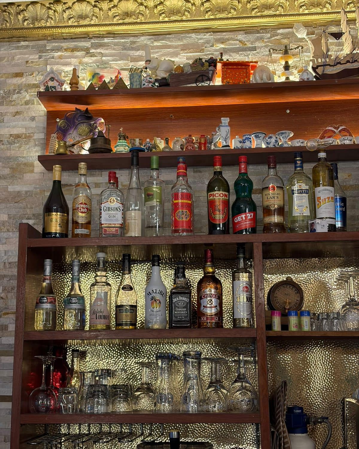 Le mur de bouteilles derrière le comptoir, du sol au plafond.