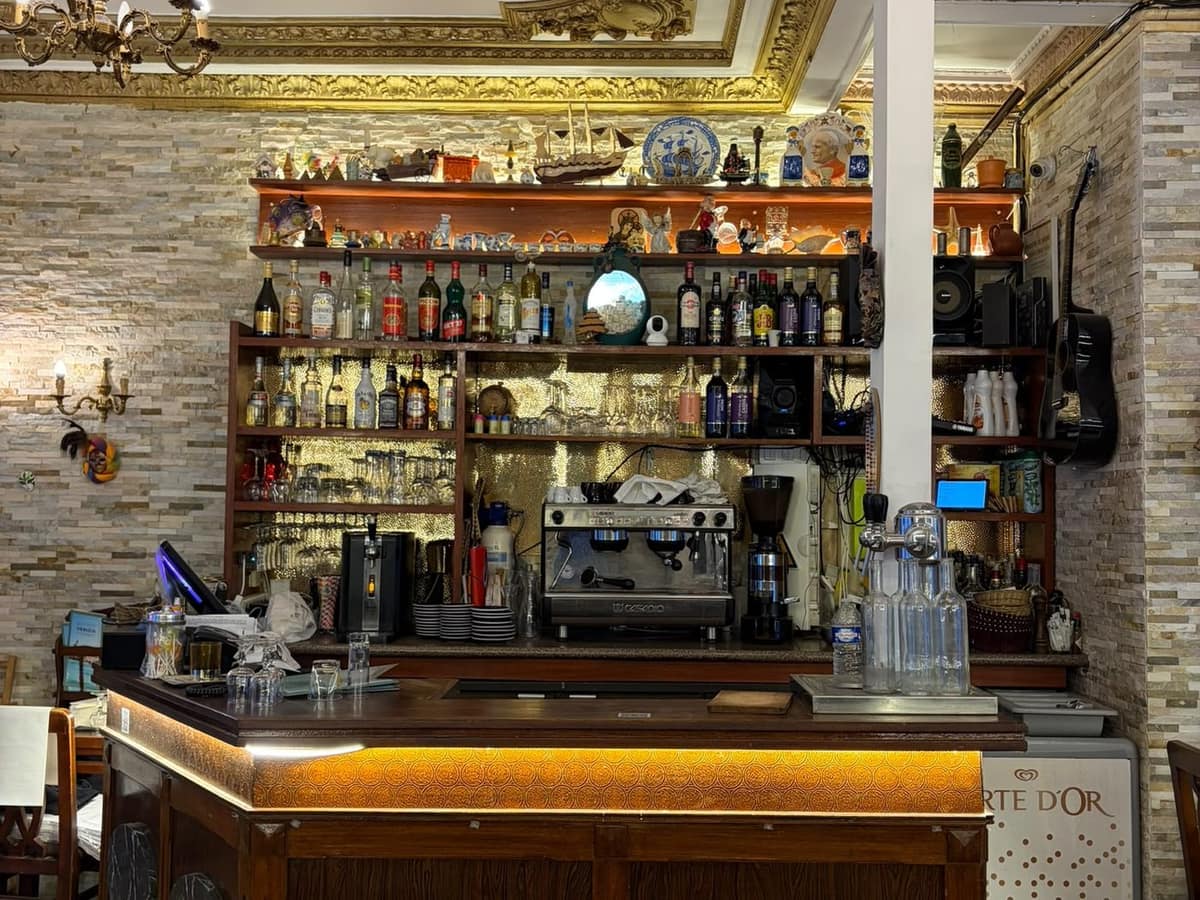 Le comptoir du Bistrot Venezia, sa machine à café et ses tireuses, sous les étagères de bouteilles.
