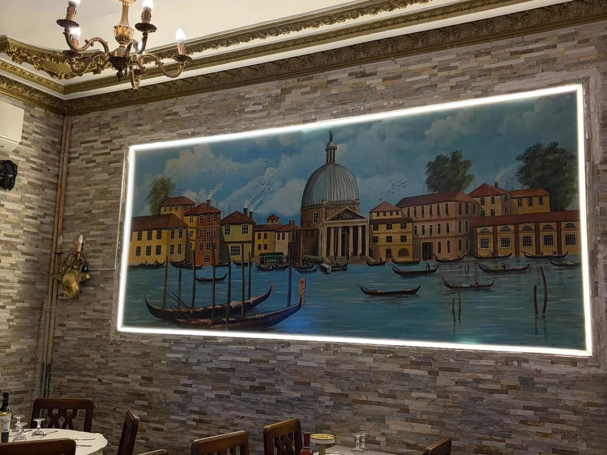 La grande toile de Venise éclairée, au-dessus des tables de la salle.