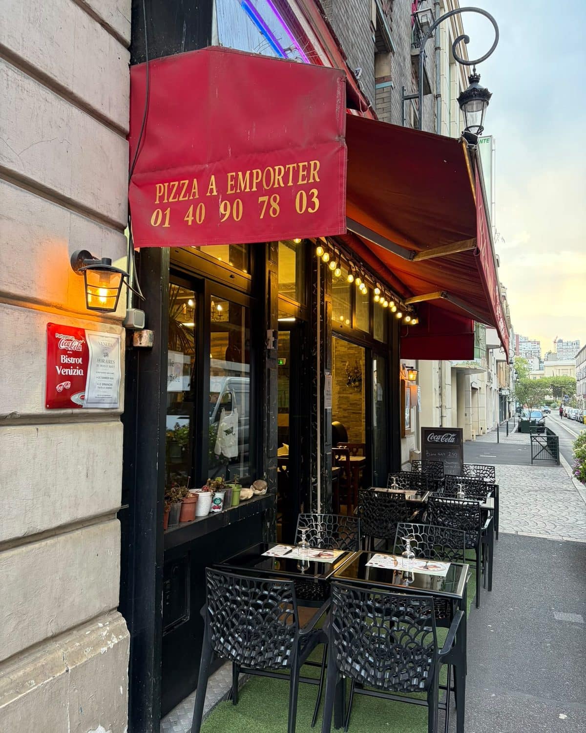 La terrasse du Bistrot Venezia rue Godefroy, sous le store « Pizza à emporter ».